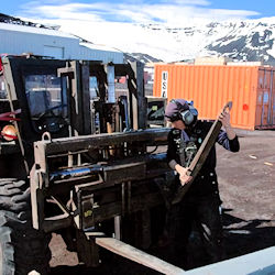 Worker replacing forklift parts