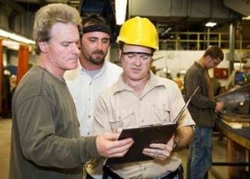 Image of supervisor checking procedures with two employees. 