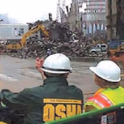 OSHA inspectors viewing a building that has been destroyed.