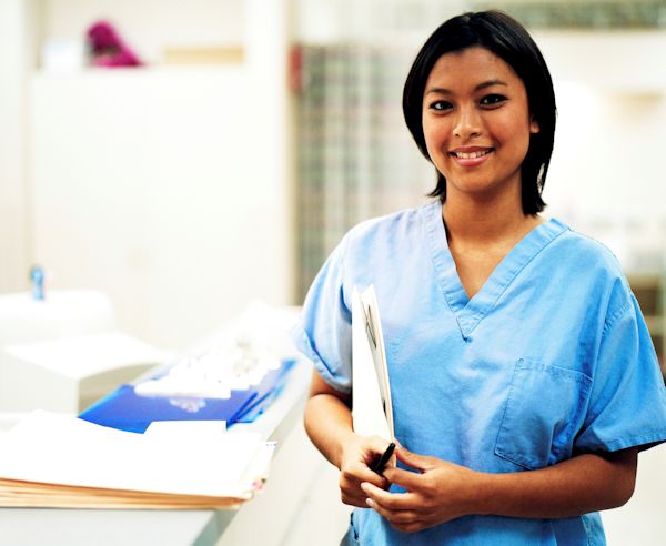 Nurse with files standing by nursing station