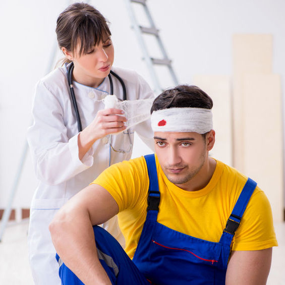 person applying bandages to co-worker who has a head wound