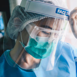 Worker wearing goggles and full face shield