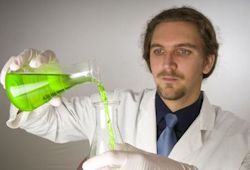 Lab worker pouring green liquid