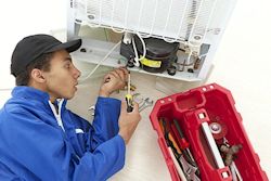 maintenance worker servicing ceiling ventilation unit