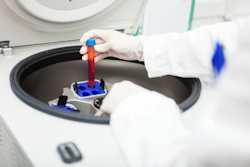 Worker placing products in a centrifuge in a lab