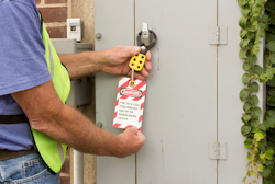 Employee checking the lock out tag out system on a door