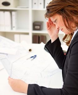 Image of stressed employee reviewing financial data.