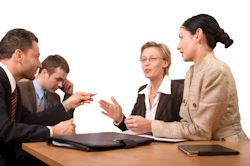 Image of four employees sitting around a table receiving training on violence reporting.