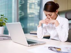 Image of stressed employee working at computer.