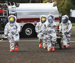 Image of workers walking wearing full PPE.