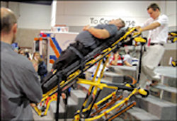 Image of workers moving patient up stairs using special equipment.