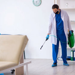 Image of worker spraying clinic room.