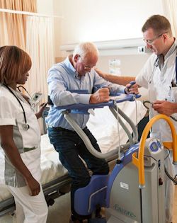 Image of medical workers moving a patient out of bed