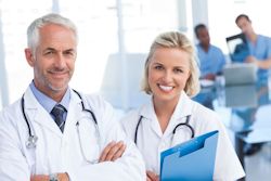 Two doctors standing with one holding a medical chart