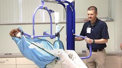 Worker using a hoyer lift to raise patient