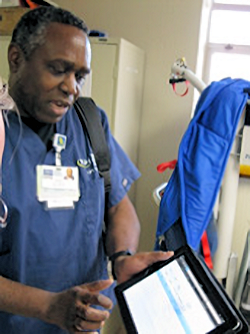 Image of healthcare worker viewing electronic charge on computer tablet