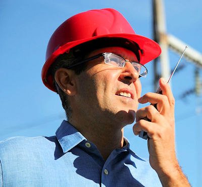 Image of a construction site supervisor communicating on a cell phone