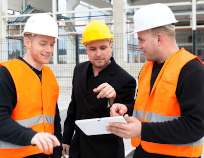 Image of three construction workers discussing Environmental Management System planning