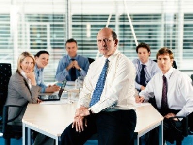 Office staff posing for a picture in a meeting room.