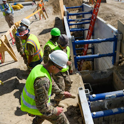 Workers setting up trench shoring.