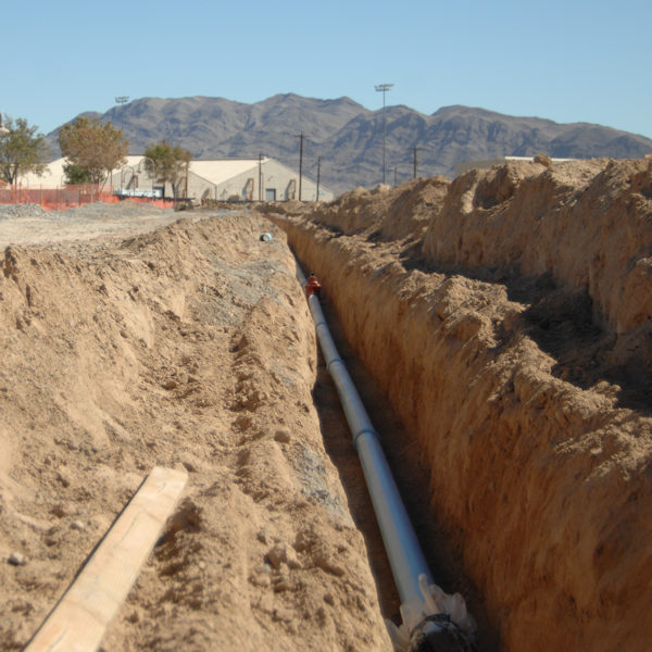 Benching in a trench with a pipe.