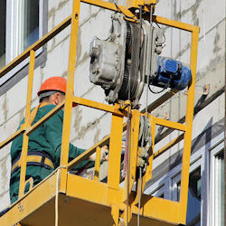 Scaffold with hoist transporting one worker