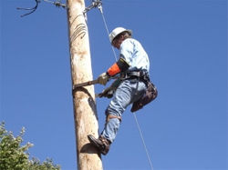 Lineman using body belt on pole