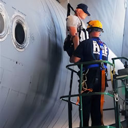 Worker helping lower a dummy during a simulated rescue. 