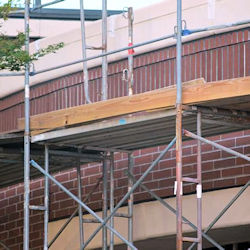 Image of a scaffold against a brick building.