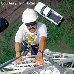 Worker climbing a tower with a fall harness