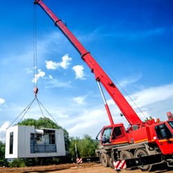 Crane hoisting a temporary mobile office 