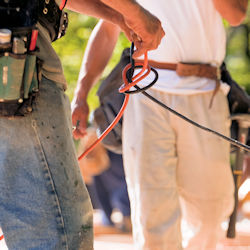 Two workers untangling electrical cords