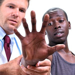 Doctor looking at a worker's hand