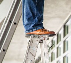 man standing on top of portable ladder