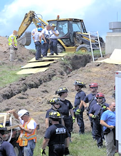 Workers and rescue from local fire departmant at the scene of a trench fatality