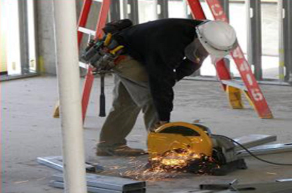 Two workers one with a nail gun pointing toward himself