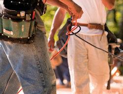 Two employees untangling extension cords