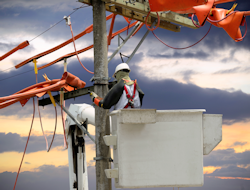 Two power company employees installing sleeves over power lines