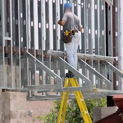 worker standing on top of ladder