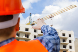 Worker looking up at crane