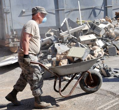 Worker cleaning up debris before continuing demolition