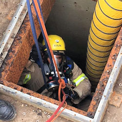 worker in confined space wearing PPE