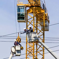 Image of workers in cranes working with heavy voltage power lines