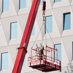 Image of worker in manlift outside building.