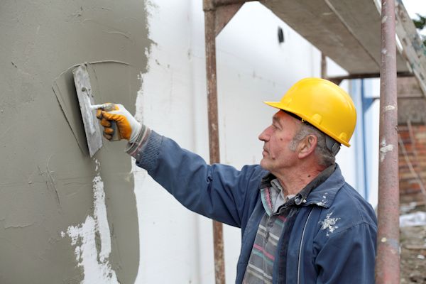 Worker applying outdoor wall coating