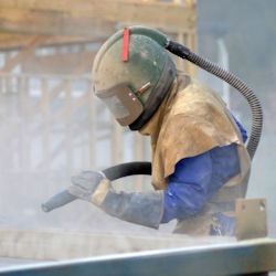 Image of worker performing blasting.