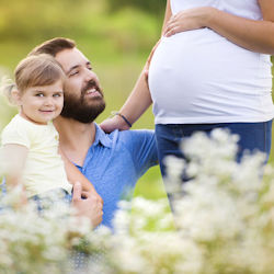 Man child and pregnant woman in a field