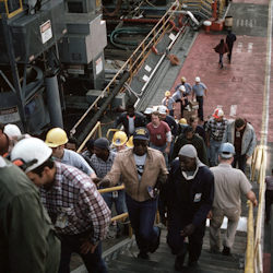 Many works on a shipyard going up or down steps