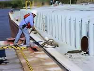 Image of worker tieing off a barge to a dock