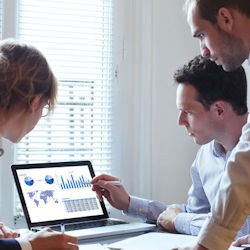 Company workers at a desk with computer looking at a baseline survey